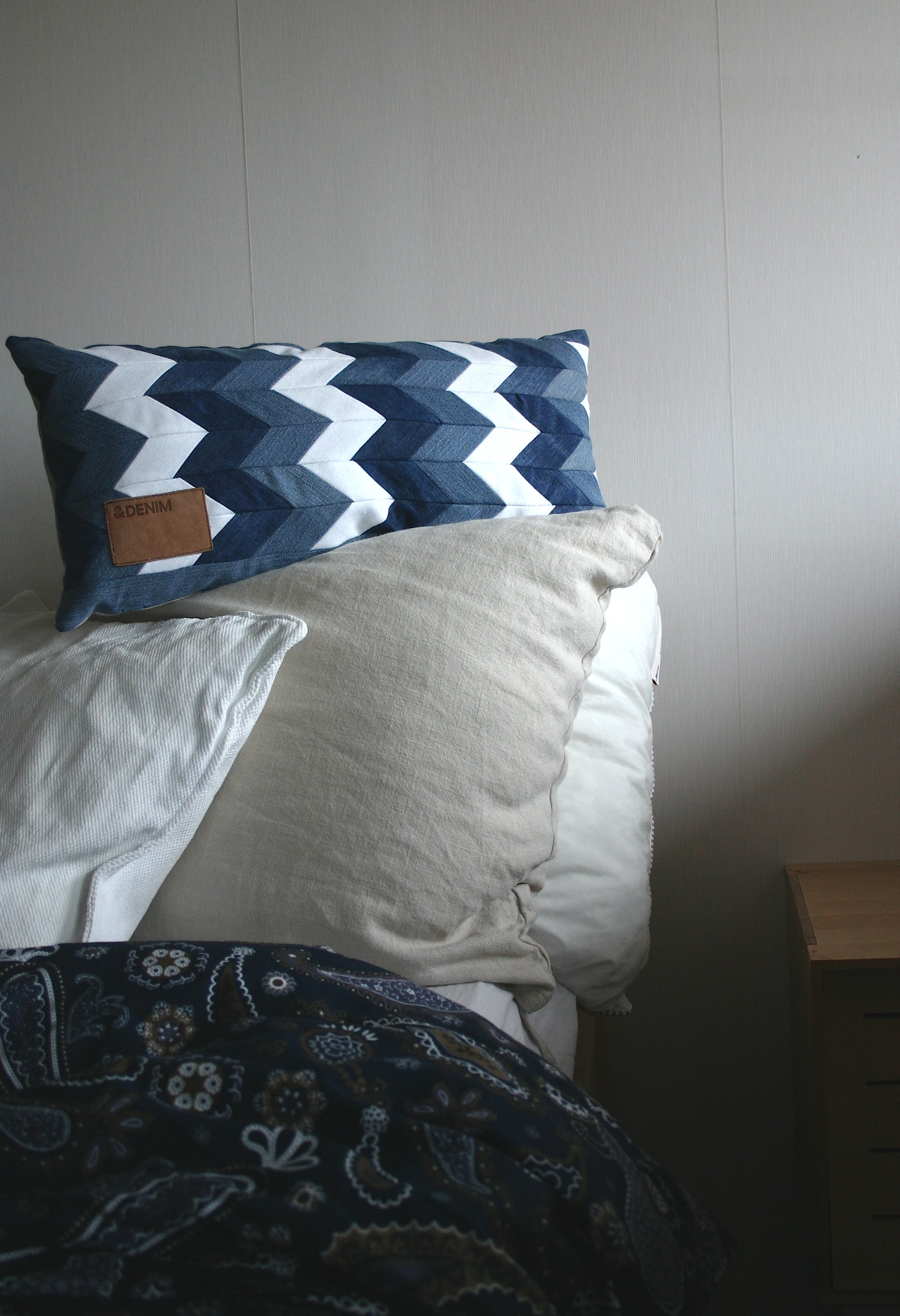 diy chevron pattern denim cushion out of old jeans and linen fabric, decorated with original patch from the recycled jeans